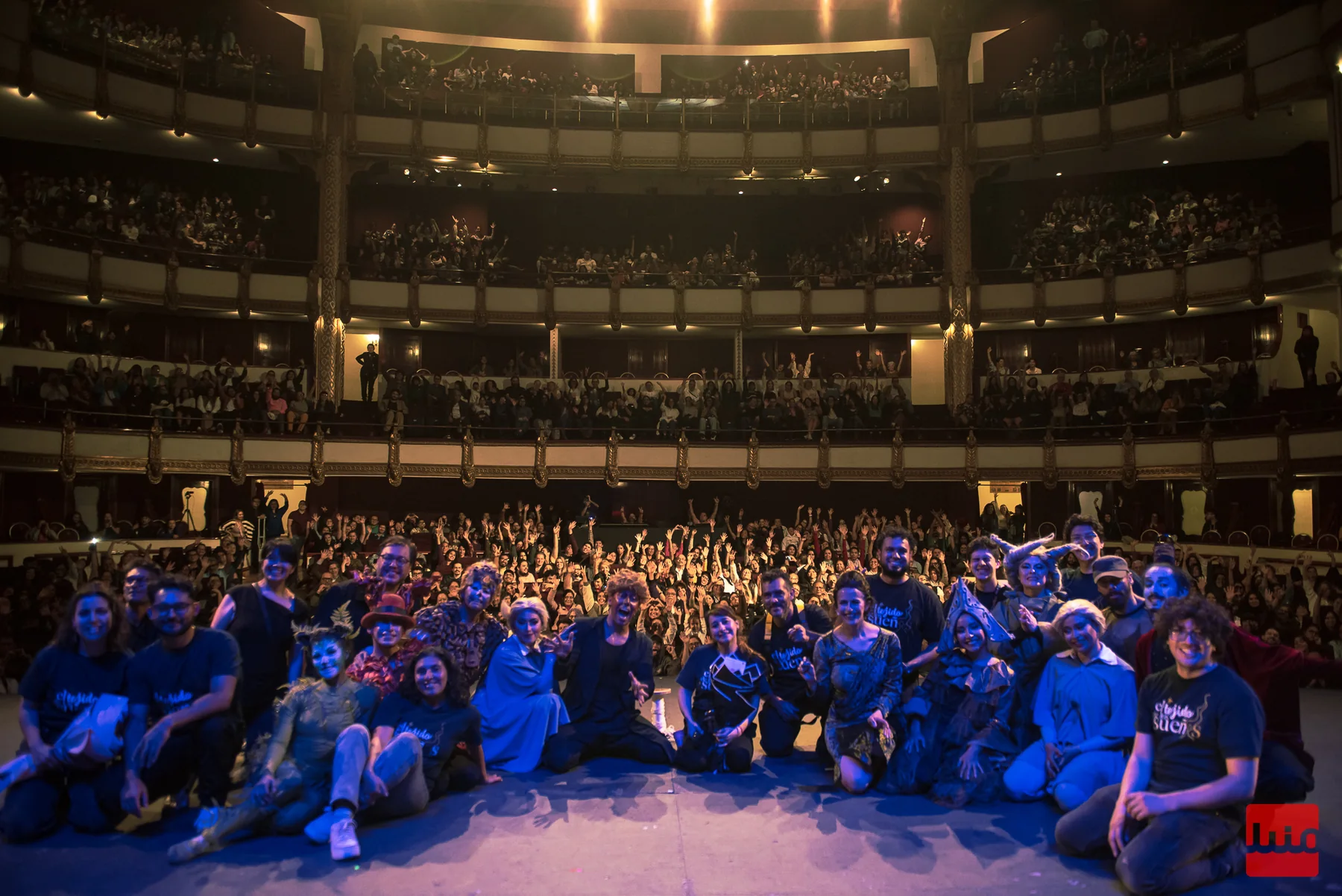 Elenco y público reunidos en una fotografía al término de una presentación.